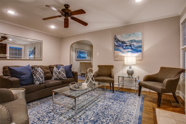 living room with crown molding, wood-type flooring, and ceiling fan