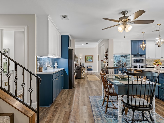 dining area featuring dark wood-type flooring and ceiling fan with notable chandelier