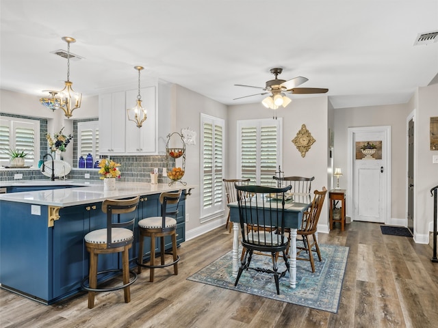 dining area with ceiling fan and wood-type flooring