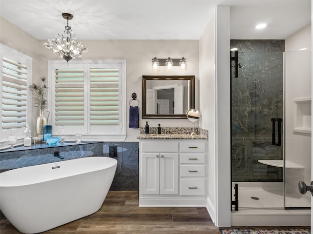 bathroom with vanity, an inviting chandelier, wood-type flooring, and separate shower and tub