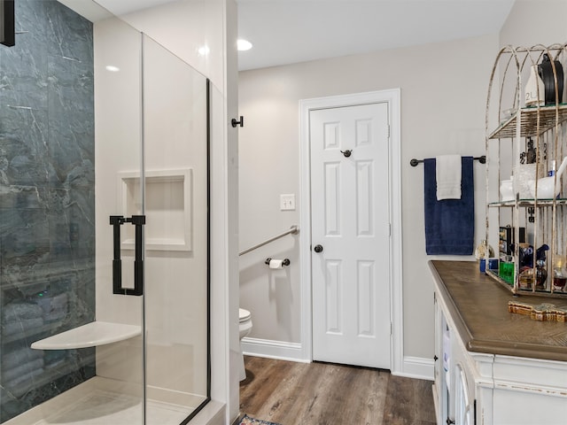 bathroom featuring vanity, toilet, walk in shower, and wood-type flooring