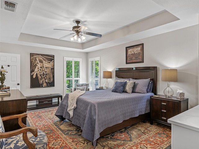 bedroom featuring a raised ceiling and ceiling fan