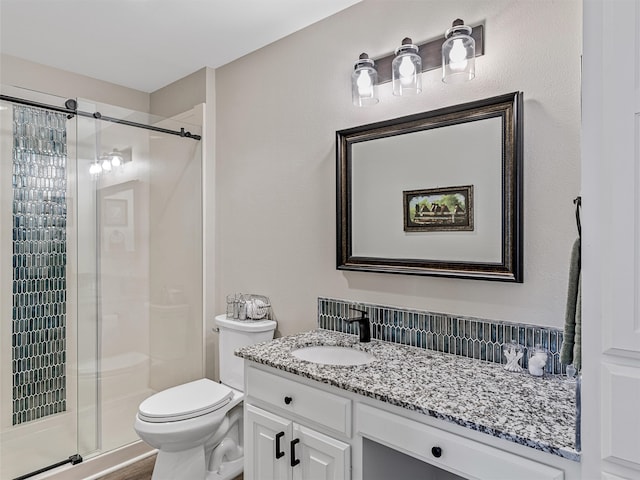 bathroom featuring vanity, toilet, and a shower with door