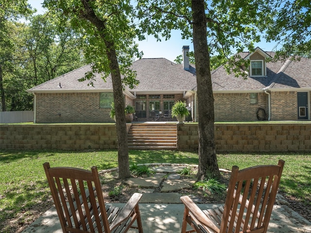 back of house with a patio area and a lawn