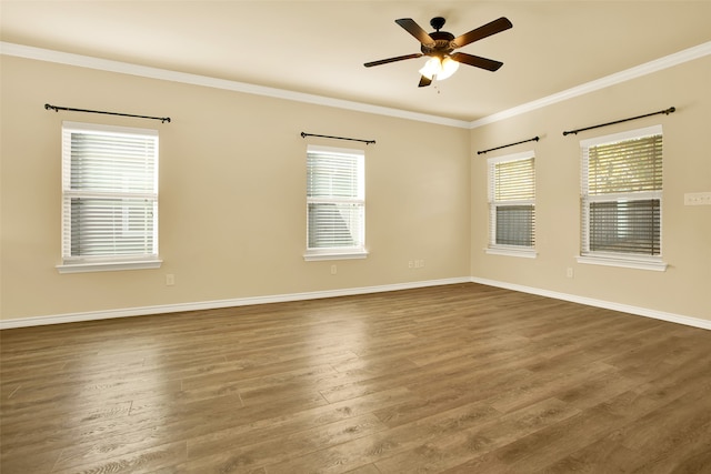 spare room with ornamental molding, a healthy amount of sunlight, and dark wood-type flooring