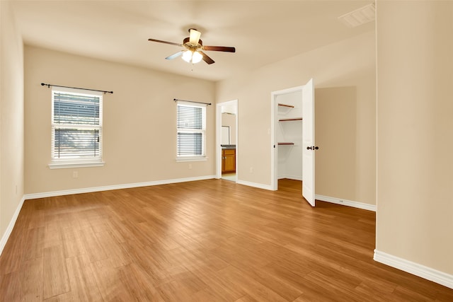 interior space with ceiling fan, multiple windows, and hardwood / wood-style floors