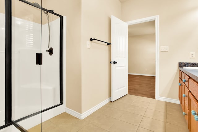 bathroom with vanity, a shower with shower door, and tile patterned flooring