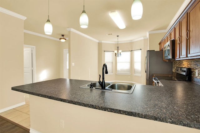 kitchen with pendant lighting, sink, crown molding, and stainless steel appliances