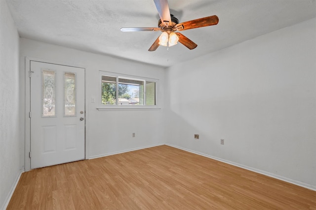 foyer featuring ceiling fan, a textured ceiling, and light wood-type flooring