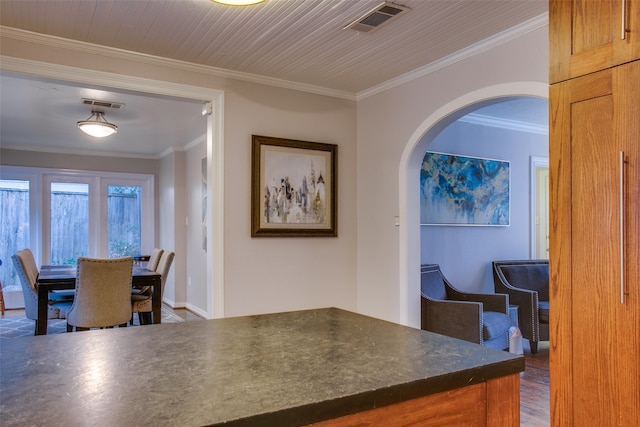 kitchen featuring crown molding and dark wood-type flooring