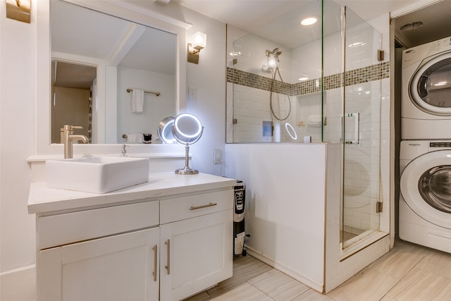 bathroom featuring vanity, stacked washer / dryer, and an enclosed shower