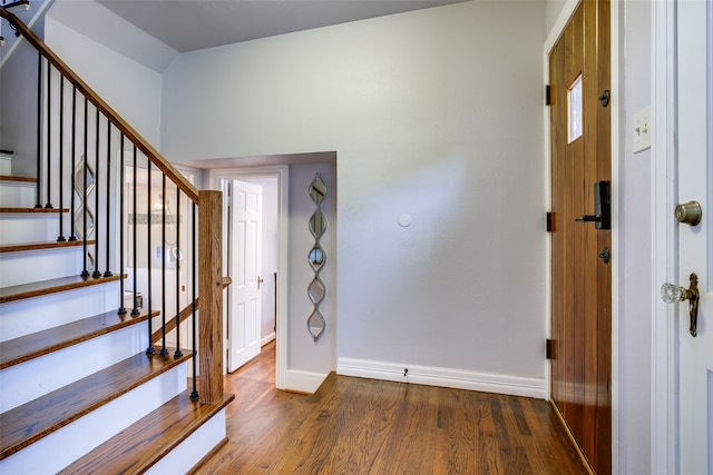 entrance foyer with dark hardwood / wood-style floors and vaulted ceiling