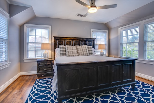 bedroom featuring multiple windows, hardwood / wood-style flooring, vaulted ceiling, and ceiling fan