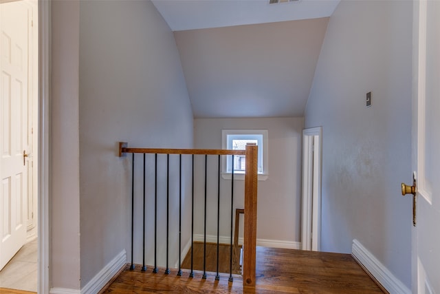 stairs featuring lofted ceiling and hardwood / wood-style floors