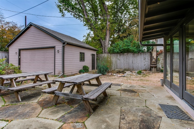 view of patio with a garage and an outbuilding