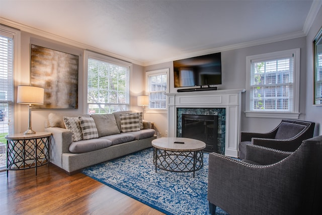 living room featuring a wealth of natural light, a high end fireplace, crown molding, and hardwood / wood-style flooring