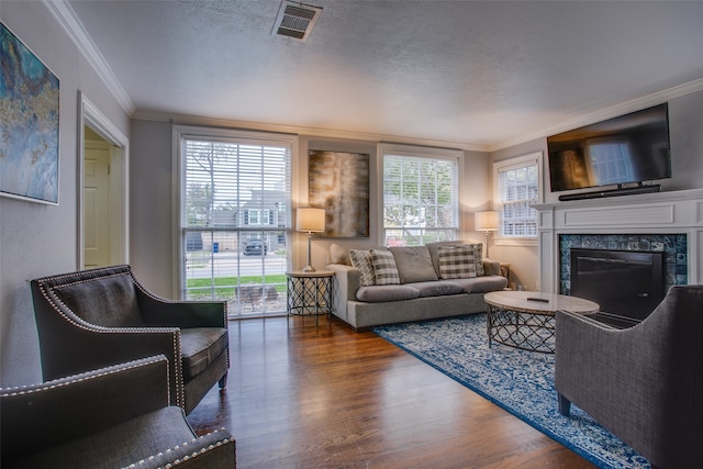 living room featuring a textured ceiling, a premium fireplace, dark hardwood / wood-style flooring, and ornamental molding