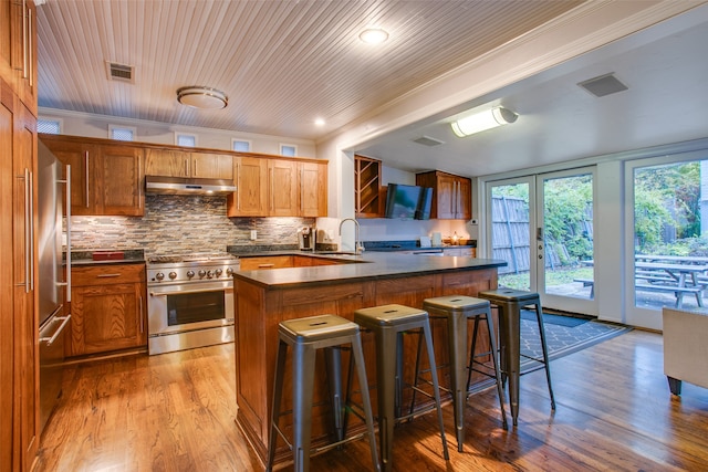 kitchen featuring light hardwood / wood-style floors, crown molding, and premium appliances