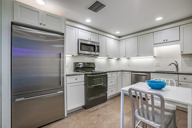 kitchen with white cabinets, tasteful backsplash, stainless steel appliances, and sink