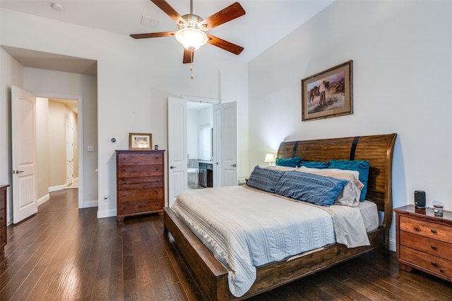 bedroom featuring ceiling fan, baseboards, wood-type flooring, and ensuite bath