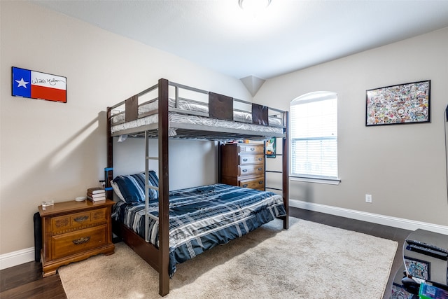 bedroom with baseboards and wood finished floors