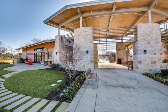 view of property exterior with a yard, french doors, and a patio