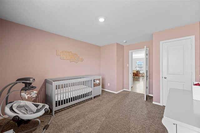 bedroom featuring dark colored carpet and a crib