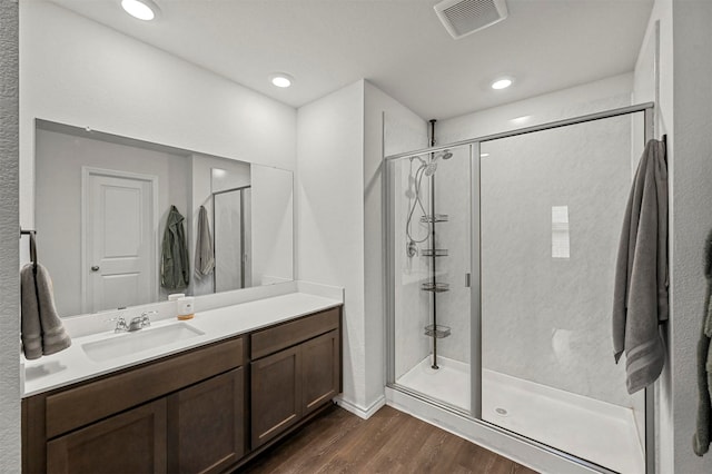 bathroom featuring a shower with door, hardwood / wood-style floors, and vanity