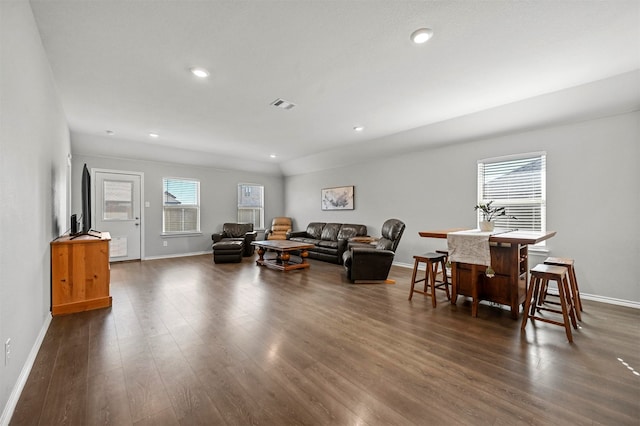 living room with indoor bar and dark hardwood / wood-style flooring