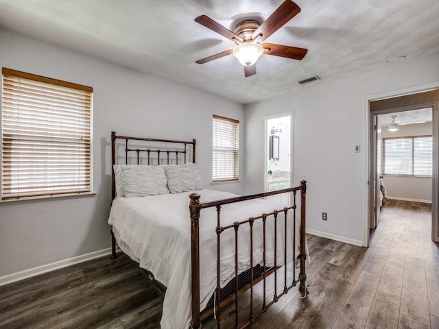 bedroom with ceiling fan, ensuite bathroom, and dark hardwood / wood-style floors