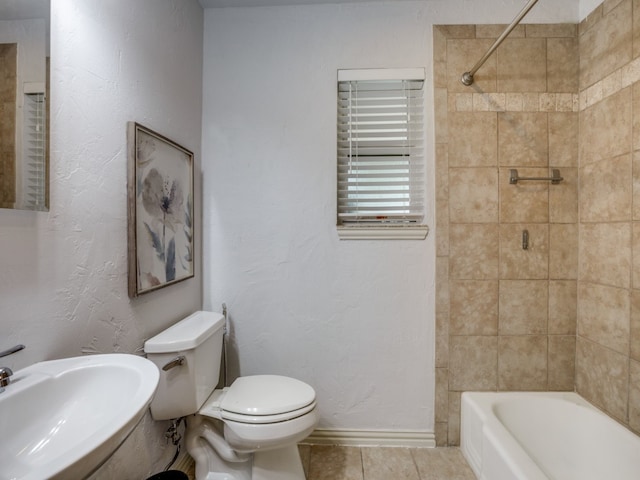 full bathroom featuring toilet, tiled shower / bath, sink, and tile patterned floors