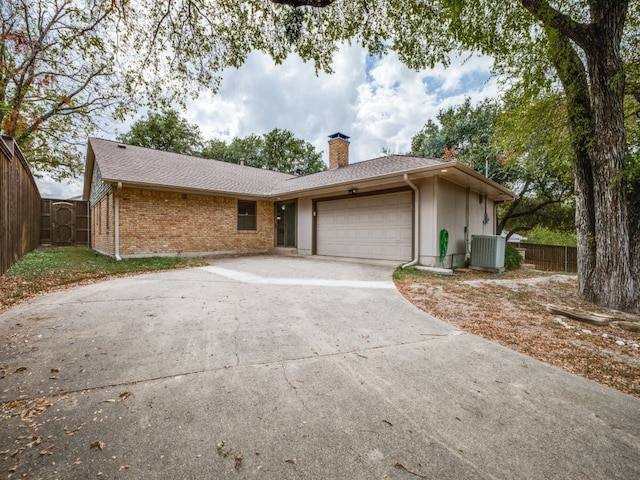 ranch-style house with a garage and central air condition unit