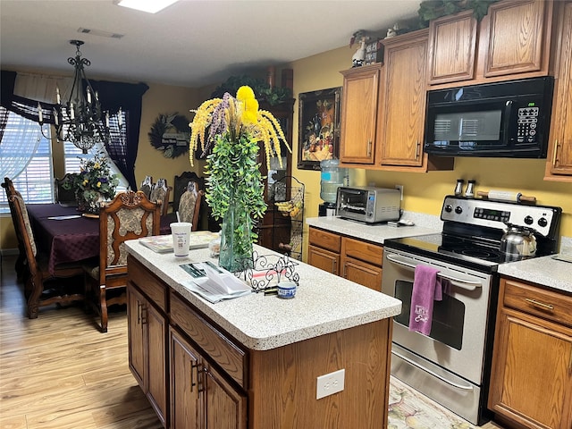 kitchen featuring light hardwood / wood-style flooring, a notable chandelier, stainless steel electric range, and a kitchen island