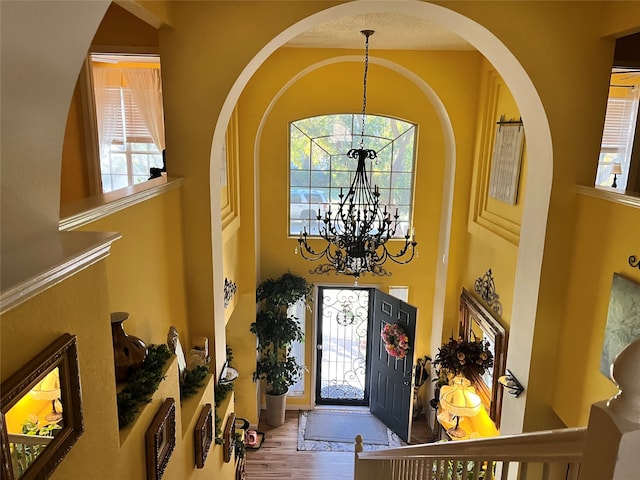 foyer entrance featuring a chandelier, hardwood / wood-style flooring, and plenty of natural light