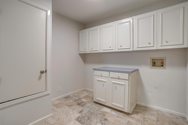 clothes washing area featuring hookup for a washing machine and cabinets