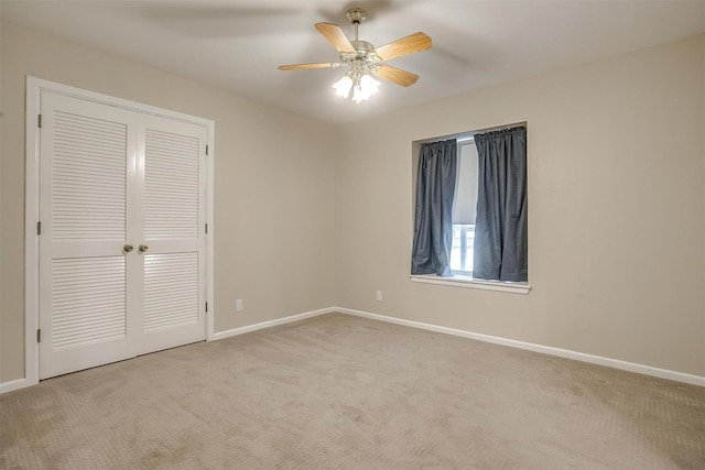 unfurnished bedroom featuring light carpet, ceiling fan, and a closet