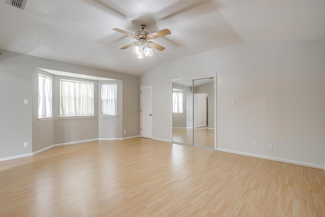 empty room featuring light hardwood / wood-style flooring, ceiling fan, and vaulted ceiling