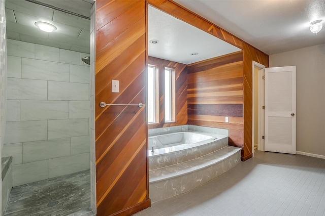 bathroom featuring a bathing tub and wood walls