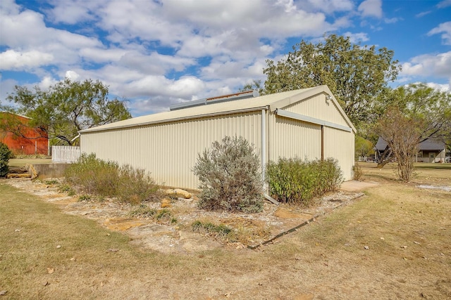 view of property exterior with an outdoor structure and a yard