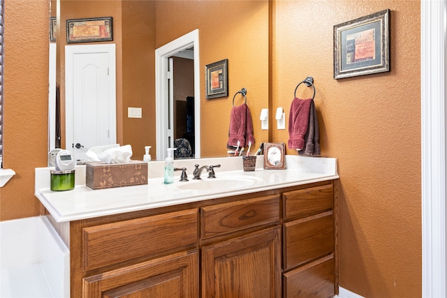 bathroom with vanity and a tub