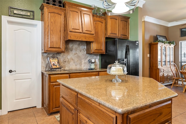 kitchen with light tile patterned floors, a stone fireplace, a center island, and crown molding