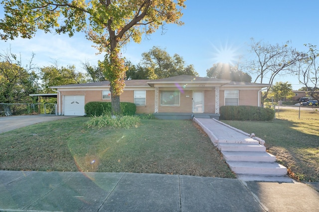 ranch-style home featuring a carport, a garage, and a front lawn