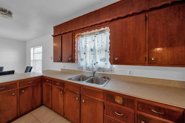 kitchen featuring sink, light tile patterned floors, and kitchen peninsula