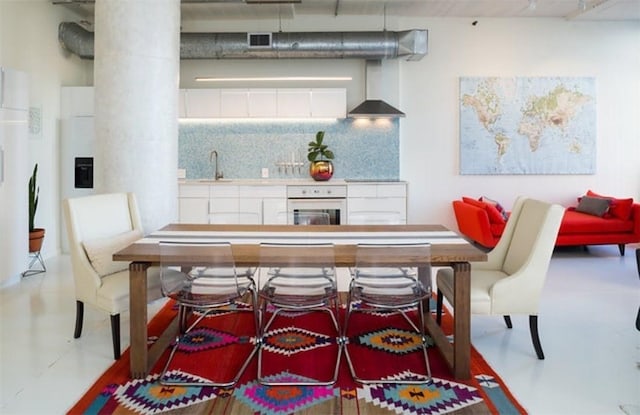 dining space featuring sink and concrete flooring