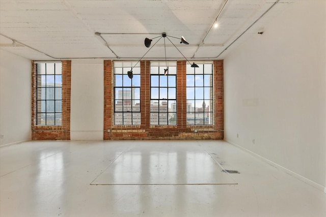 empty room with rail lighting and concrete floors