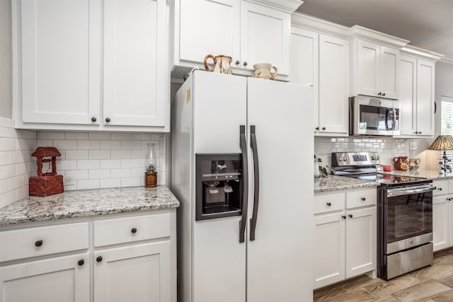 kitchen with stainless steel appliances, light wood-type flooring, and white cabinets