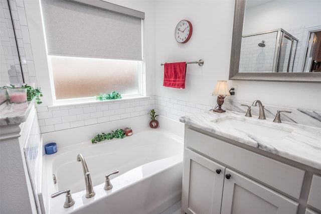 bathroom with vanity and shower with separate bathtub