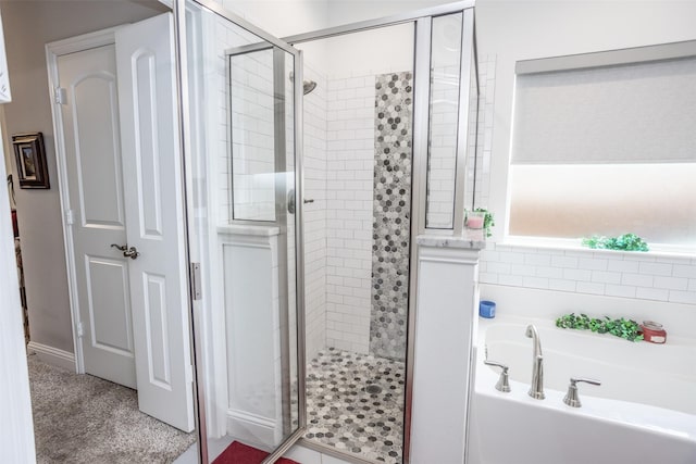 bathroom featuring independent shower and bath