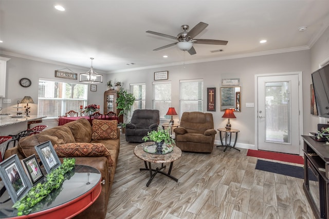 living room featuring ceiling fan with notable chandelier, ornamental molding, and light hardwood / wood-style floors