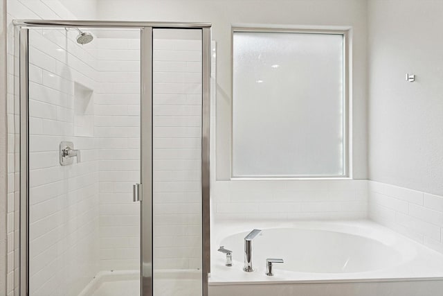 bathroom featuring independent shower and bath